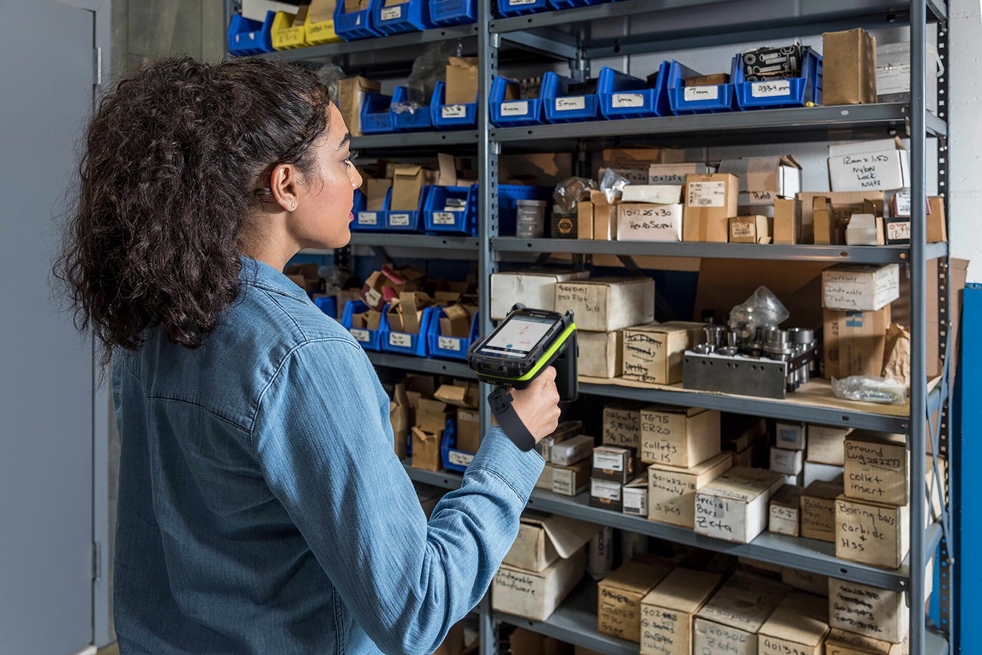 woman scanning multiple shelves of products with a handheld scanner