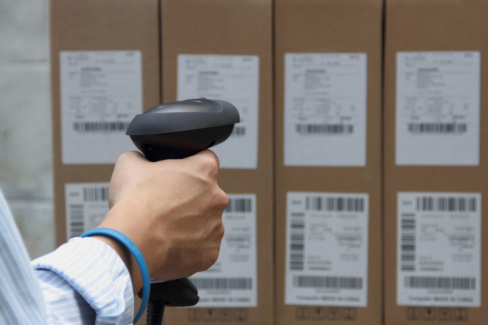 Man holding a barcode scanner and scanning labels at a distance