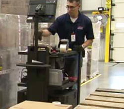 Warehouse employee using a Newcastle powercart next to pallets