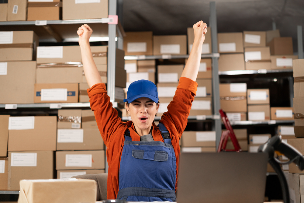Woman happy in warehouse with arms raised