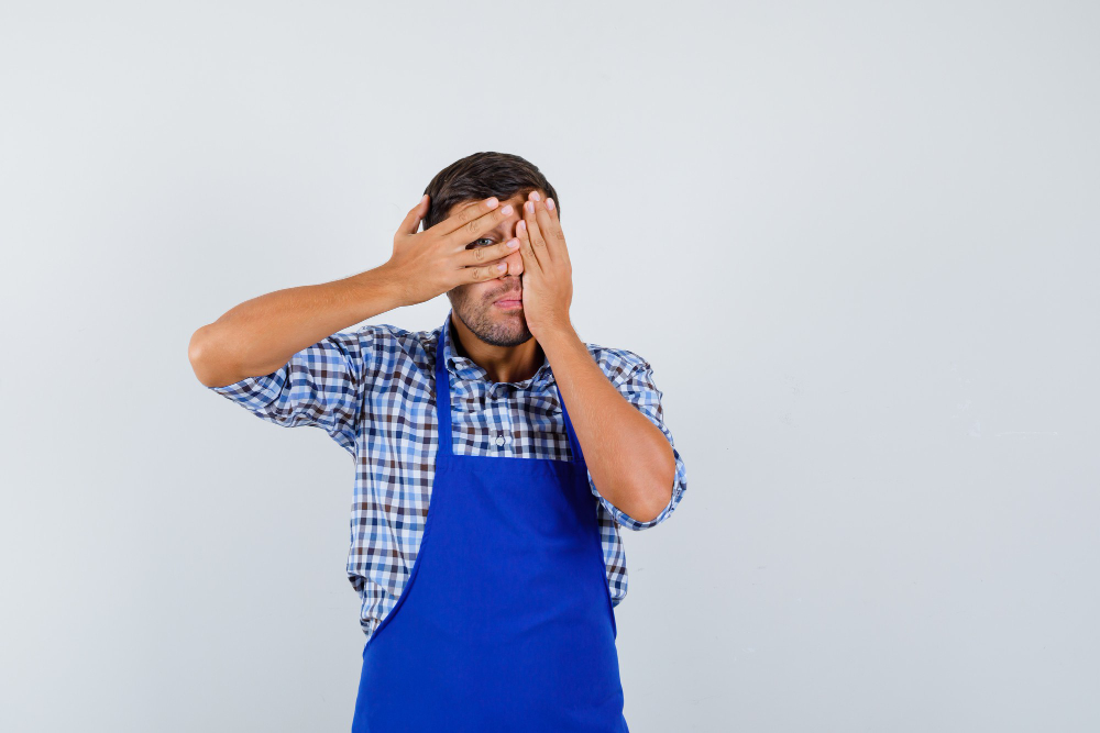 Man with apron covering eyes